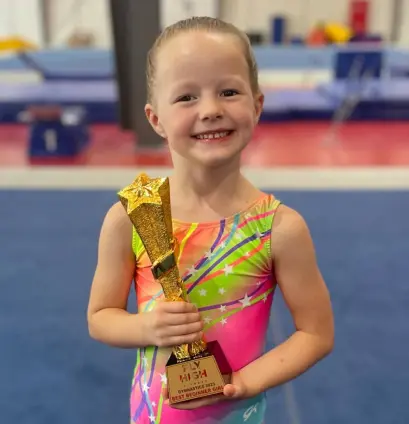 A young gymnast with a trophy